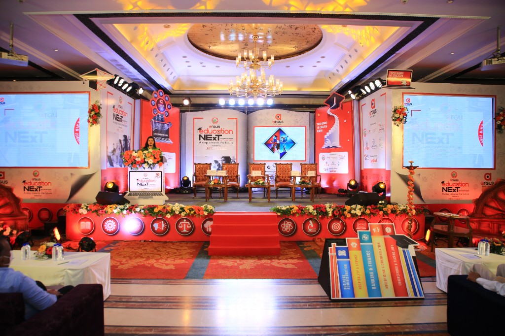 Main stage with open-book backdrop and Argus Education Next branding